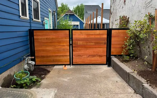 Finished cedar horizontal swing driveway gate in black frame, straight-on view — Interstate Gate Repair