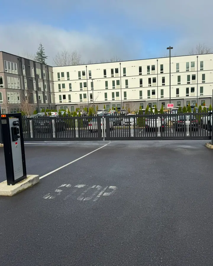 Black bi-parting slide gate with barrier arm at Casey apartment complex — Interstate Gate Repair
