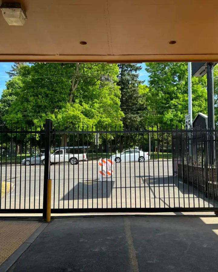 Black ornamental iron sliding security gate at commercial motel entrance — Interstate Gate Repair